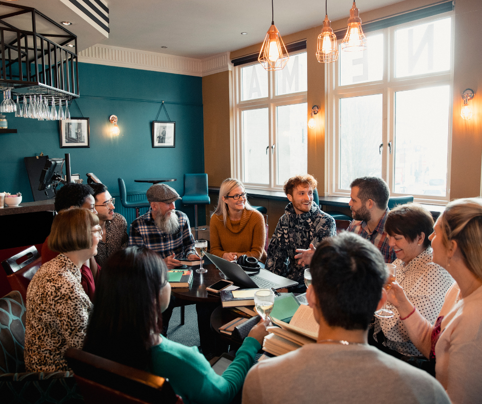 Group of people gathered around a table in lively conversation