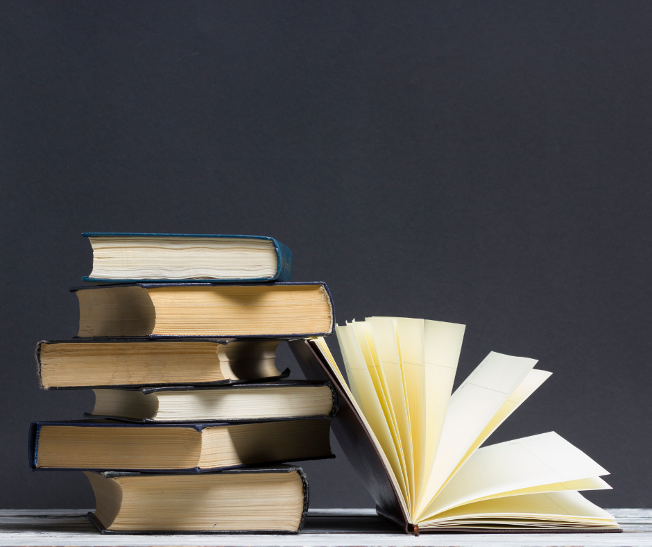 Stack of well-read books beside an open book